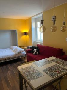 ein Wohnzimmer mit einem roten Sofa und einem Bett in der Unterkunft Casa Anna Giulia in Castione della Presolana