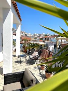 Un balcón con un patio con sillas y una mesa. en Litsa_house, en Skiathos