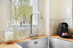 un lavandino in cucina con finestra di Suite Haussmann by Les Maisons de Charloc Homes a Parigi
