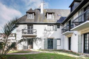 une maison blanche avec un toit et des fenêtres noirs dans l'établissement Sarah 3 - Appt à avec jardin à 200 m de la plage, à Fréhel