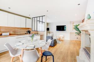 une cuisine et un salon avec une table et des chaises dans l'établissement Sarah 3 - Appt à avec jardin à 200 m de la plage, à Fréhel