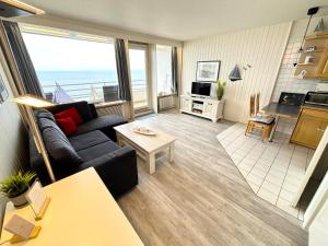 ein Wohnzimmer mit einem Sofa und einem Tisch in der Unterkunft Ferienpark Sierksdorf App 321 - Strandlage in Sierksdorf
