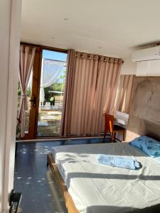een slaapkamer met een bed, een bureau en een raam bij Beus home in Durrës