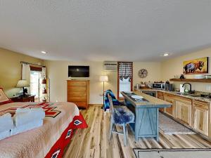 a bedroom with a bed and a desk and a kitchen at Double Eagle 2 in Alto