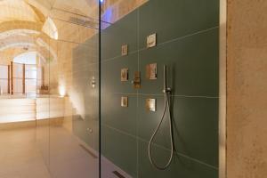 y baño con ducha y pared verde. en Endea Suite Rooms & Lounge SPA, en Matera