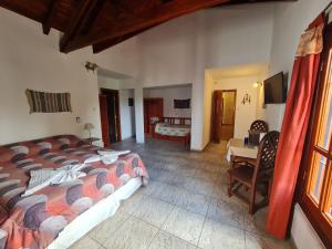 米娜克拉韋羅的住宿－Cabanas Las Pencas, HOSTERIA，一间卧室配有一张床、一张桌子和一张床