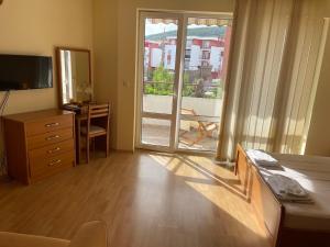 1 dormitorio con 1 cama, vestidor y puerta corredera de cristal en Fort Noks SP apartments-Elenite, en Elenite