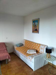 un sofá naranja en una habitación con mesa en T2 vue mer à Porticcio, proche aéroport Ajaccio, en Porticcio
