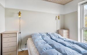 1 dormitorio con cama con sábanas azules y ventana en Pet Friendly Home In Hurup Thy With House Sea View, en Doverodde