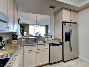 a kitchen with a stainless steel refrigerator and cabinets at Indigo East 1203 in Perdido Key