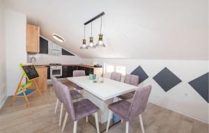 a kitchen and dining room with a white table and purple chairs at Amazing Apartment In Maslenica in Maslenica