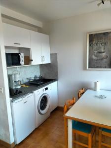cocina con lavadora y mesa en T2 vue mer à Porticcio, proche aéroport Ajaccio, en Porticcio