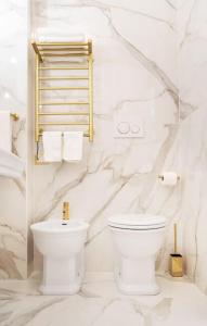 a white bathroom with a toilet and towels at In Villa Apartment in Rome