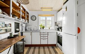 Una cocina con gabinetes blancos y una ventana grande. en 2 Bedroom Pet Friendly Home In Svaneke, en Svaneke