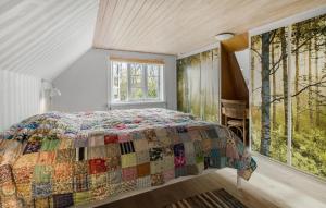 Un dormitorio con una cama con una colcha encima en 2 Bedroom Pet Friendly Home In Svaneke, en Svaneke