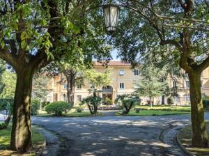 a large building with a lot of trees and a street at In Villa Apartment in Rome