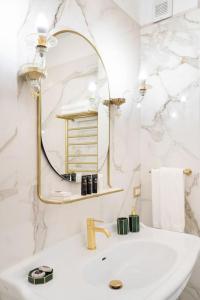 a white bathroom with a sink and a mirror at In Villa Apartment in Rome