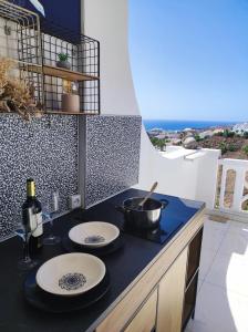 a kitchen with two plates and a pot on a counter at Sunshine Escape with ocean view in Adeje