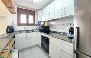 a kitchen with white cabinets and a black dishwasher at 3 Bedroom Cozy Home In Peñíscola in Peñíscola