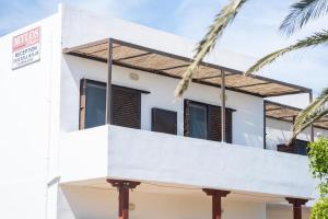 a white house with a balcony and palm trees at MYLOS (6) in Chania +1 photo