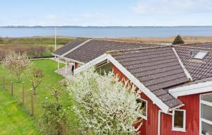 a red house with a view of the water at Nice Home In Bog By With Wifi in Bogø By