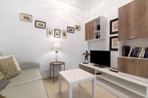 Il comprend un salon blanc doté d'un canapé et d'une télévision. dans l'établissement Ático Margarita, à Las Palmas de Gran Canaria