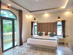 a bedroom with a large bed and two windows at Hang Meas Boutique in Kampot