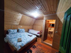 1 dormitorio con 1 cama en una habitación de madera en bujtina 2, en Valbonë