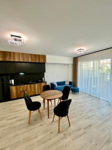 uma sala de estar com uma mesa e cadeiras e um sofá em Premium Residence ApartHotel em Oradea