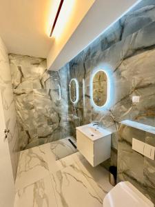 uma casa de banho com um lavatório e uma parede em mármore em Premium Residence ApartHotel em Oradea