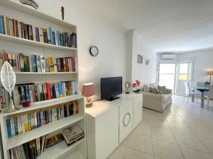 a living room with book shelves filled with books at Castillo de Moraira in Moraira