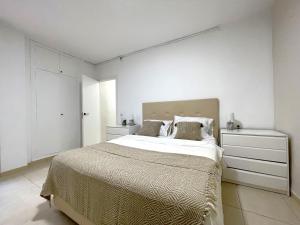 a bedroom with a large bed and a white wall at Castillo de Moraira in Moraira