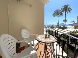 a balcony with tables and chairs and a view of the beach at Castillo de Moraira in Moraira