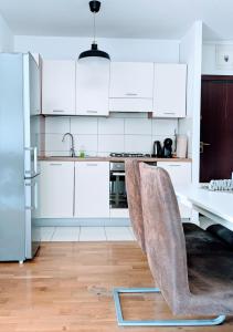 a kitchen with white cabinets and a table with chairs at DoMa-Lu apartment with free parking in Velika Mlaka