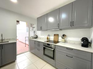a kitchen with stainless steel appliances and gray cabinets at Castillo de Moraira in Moraira +12 photos
