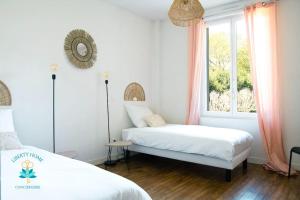 a bedroom with two beds and a window at Le 17M - Maison Basque d'Occitanie Clim Jardin Parking in Castelginest