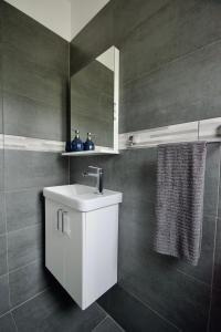 ein Badezimmer mit einem weißen Waschbecken und einem Spiegel in der Unterkunft Apartmani Rajković in Matulji