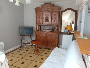 um quarto com uma grande cómoda em madeira e uma cama em Varzyfiz em Varzy