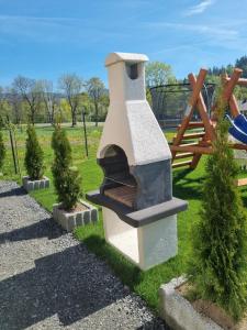 a stone oven in a park with a playground at Domki U Uli in Wisła