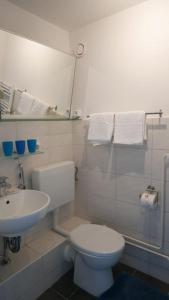 een witte badkamer met een toilet en een wastafel bij Weser-Panoramablick 10. OG. ColumbusCenter in Bremerhaven