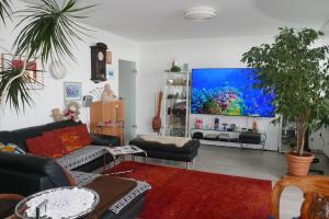 een woonkamer met een grote flatscreen-tv bij Weser-Panoramablick 10. OG. ColumbusCenter in Bremerhaven