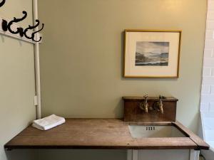 baño con lavabo y una foto en la pared en Ardtornish House Victorian Apartments, en Estroncia