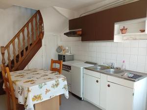 uma pequena cozinha com um lavatório e uma mesa com uma toalha de mesa em Varzyfiz em Varzy