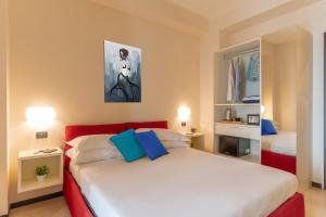 ein Schlafzimmer mit einem roten und weißen Bett mit blauen Kissen in der Unterkunft Comfort House in Sorrent