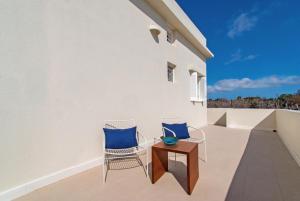 two chairs and a table on a balcony at At The Side Of The Castle in Plaka Milou