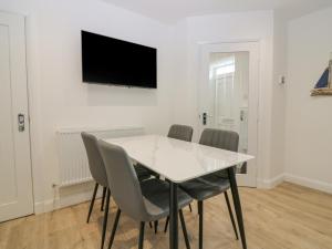 a dining room with a white table and chairs at 2 College Bounds in Fraserburgh