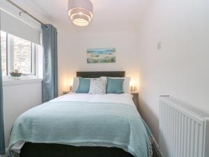 a bedroom with a bed with a green blanket at 2 College Bounds in Fraserburgh