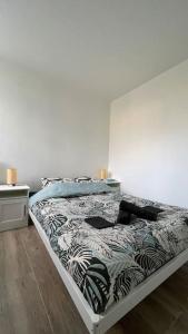 uma cama num quarto com uma parede branca em Le Lumineux em Le Mée-sur-Seine