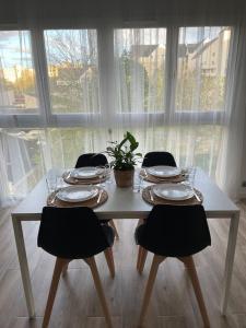 uma mesa com cadeiras e pratos e uma planta sobre ela em Le Lumineux em Le Mée-sur-Seine