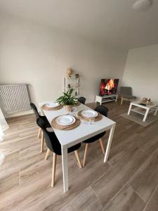uma mesa branca e cadeiras numa sala de estar em Le Lumineux em Le Mée-sur-Seine